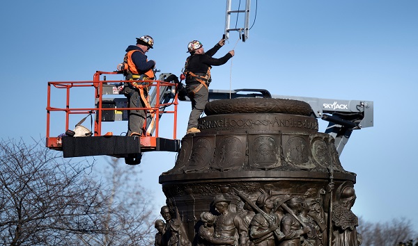 Workers lower a ladder into a monument as they dismantle the Confederate Memorial at Arlington National Cemetery December 20, 2023, in Arlington, Virginia. CREDIT: BRENDAN SMIALOWSKI/GETTY IMAGES