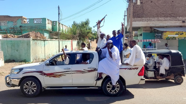 Armed Sudanese civilians wave weapons and chant slogans as they drive through the streets of Gedaref city in eastern Sudan on Jan. 1, 2024. (AFP via Getty Images)