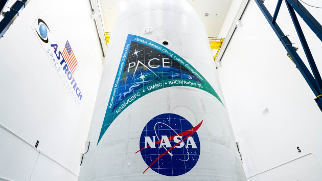 NASA and SpaceX technicians safely encapsulate NASA's PACE (Plankton, Aerosol, Cloud, ocean Ecosystem) spacecraft in Space's Falcon 9 payload fairings on Jan. 30, 2024, at the Astrotech Space Operations Facility near the agency's Kennedy Space Center in Fla. (Katie Mellos/NASA Goddard)
