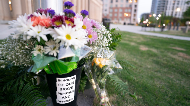 Flowers in memory of fallen law enforcement officers accumulate at the base of a flag pole outside the Federal Courthouse on April 30, 2024 in Charlotte, North Carolina. (Sean Rayford/Getty Images)