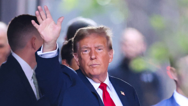 Former US President Donald Trump waves as he departs Trump Tower for Manhattan Criminal Court, to attend the first day of his trial for allegedly covering up hush money payments linked to extramarital affairs, in New York City on April 15, 2024. -- CHARLY TRIBALLEAU/AFP via Getty Images