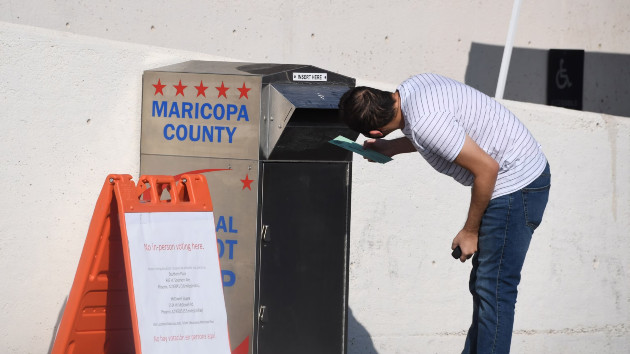In this Oct. 18, 2020 file photo, a person is seen depositing their mail-in ballots for the U.S. presidential election at a ballot collection box in Phoenix. (Robyn Beck/AFP via Getty Images)