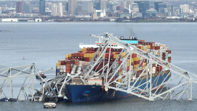 In this aerial image, the steel frame of the Francis Scott Key Bridge sits on top of a container ship after the bridge collapsed, Baltimore, March 26, 2024. (Jim Watson/AFP via Getty Images)