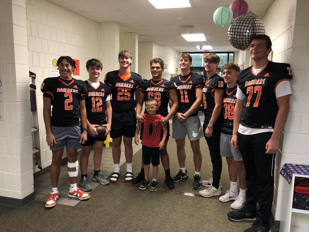 Rylie Cheatham, a first grader in Mrs. Roger’s class, and his brother Kyler Cheatham and the Macomb Bombers football pla…