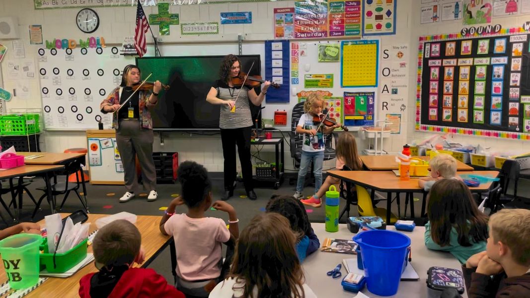 Ellie Gardner, student in Mrs. Scott’s 1st grade class, plays the violin with mom and violin teacher.  #MAC185