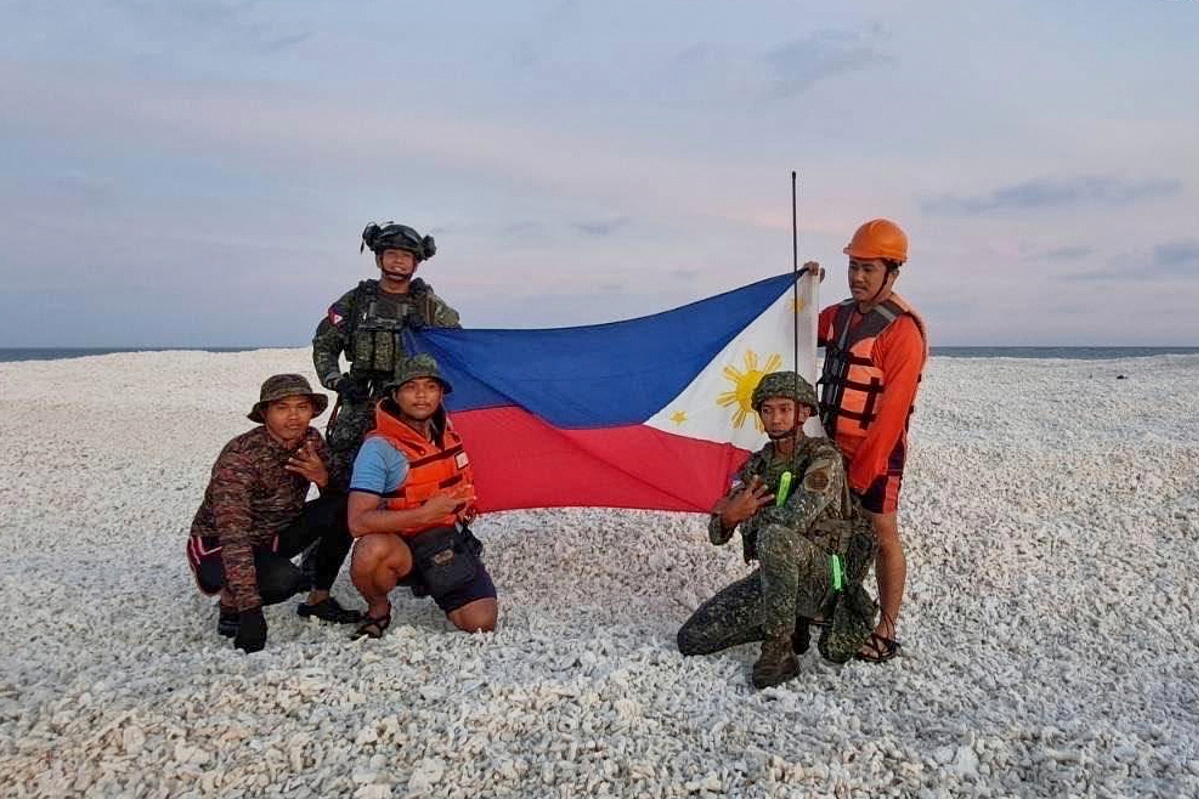 China and Philippines display their flags on a disputed South China Sea outcropping