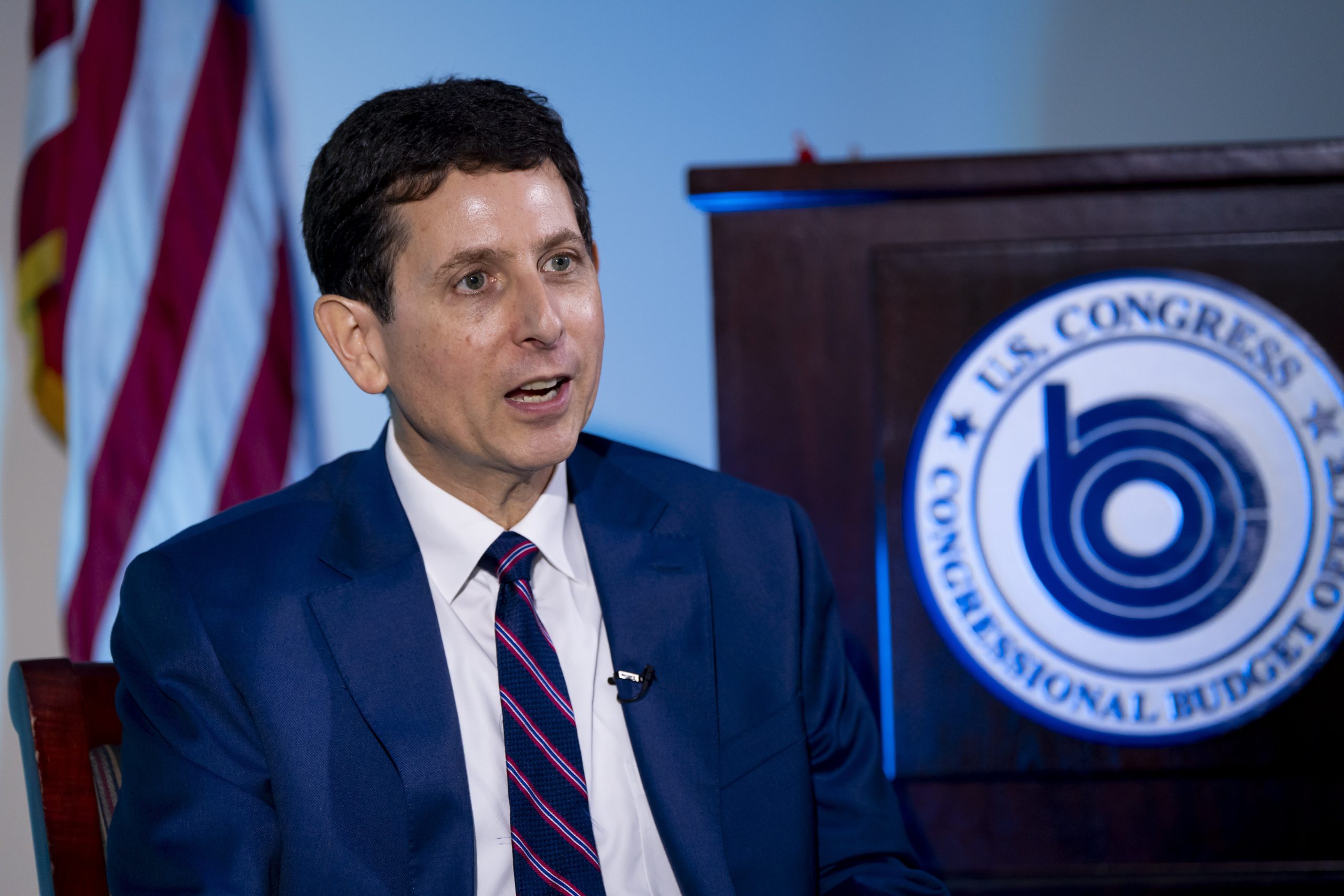 He’s the budget scorekeeper for Congress. Lately, it’s been a tough job