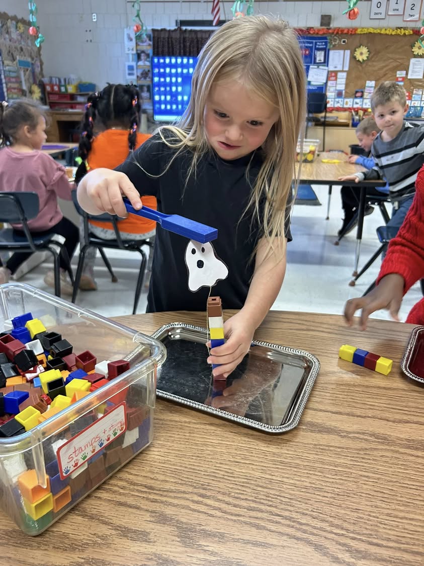 Making ghosts float in Mrs. Mabrey’s room. Then measuring how tall they are with unifix cubes and counting to see which…