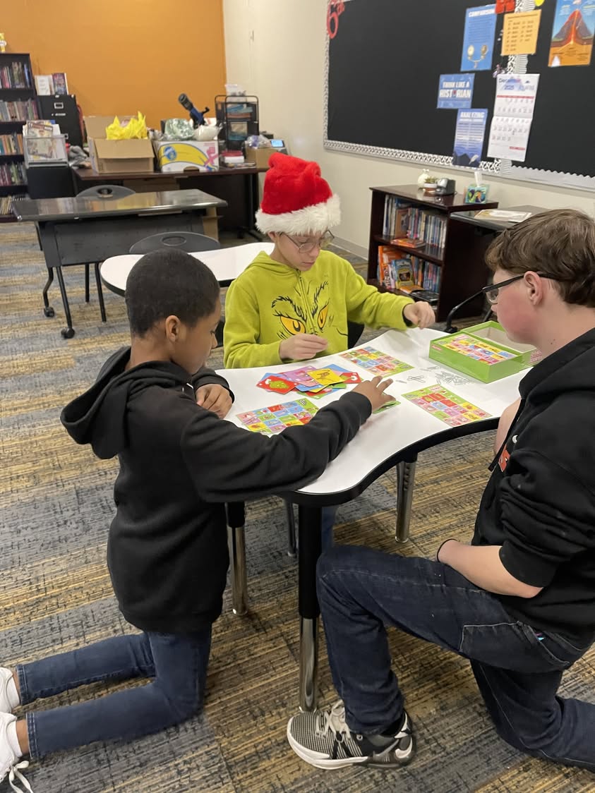 Mrs. Doll’s 7th grade Social Studies students took a break to try out Grinch Bingo on “Grinch Day” at Macomb Middle Scho…